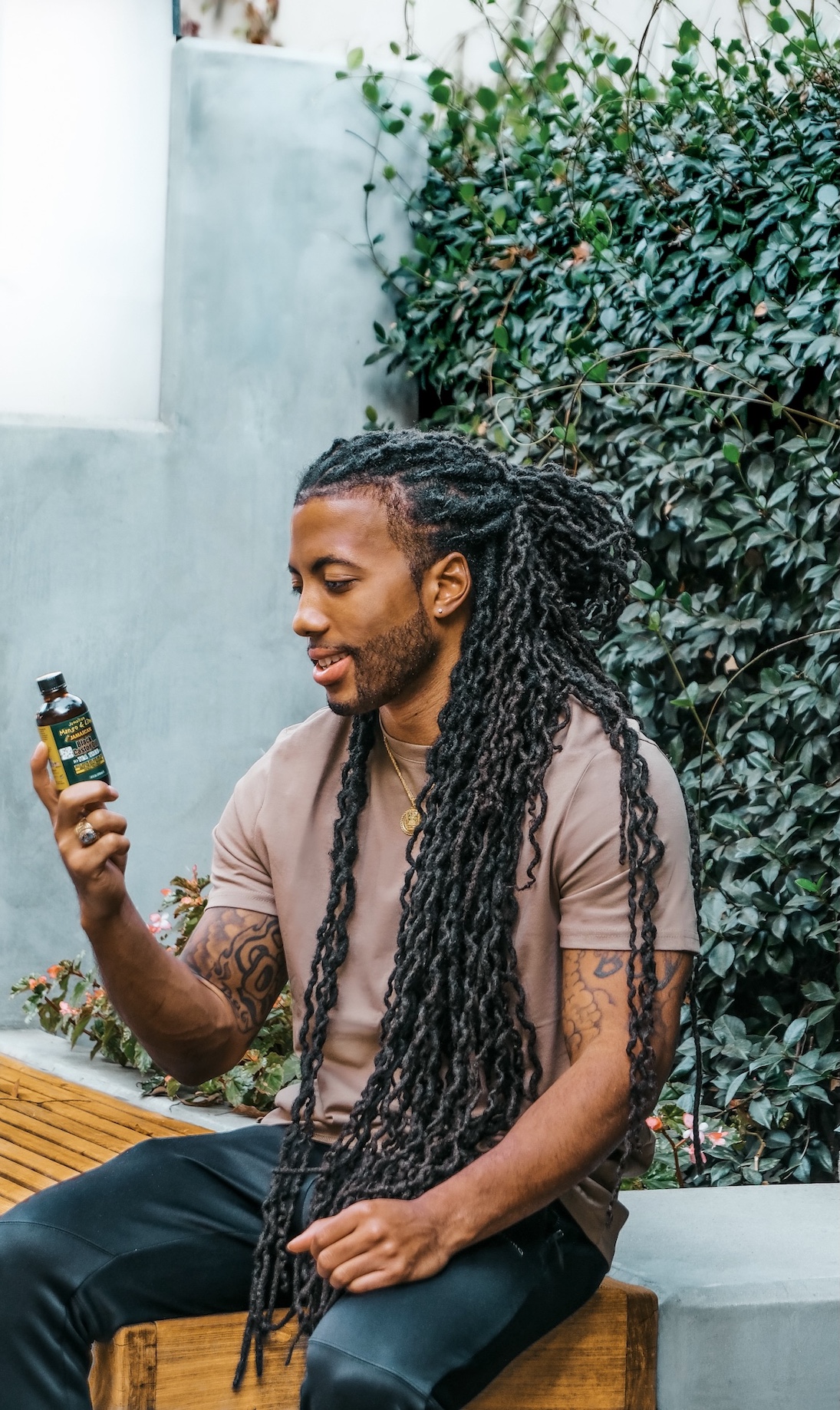 Chace Cauthen Holding Jamaican mango and lime Jamaican black castor oil for hair growth